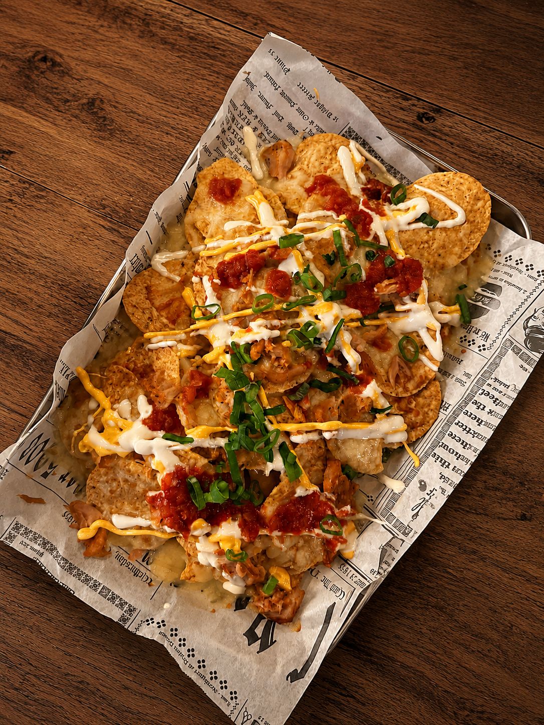 Dirty Nachos — mozzarellagratinerade nachos med pulled chicken, ostsås, creme fraiche, salsa och salladslök